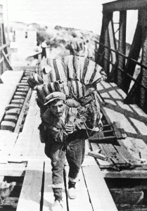 Έλληνας πρόσφυγας περνά από την κατεστραμμένη γέφυρα του Στρυμώνος, κατευθυνόμενος από την βουλγαροκρατούμενη Ανατολική Μακεδονία στη γερμανική ζώνη Κατοχής, στην Κεντρική Μακεδονία.