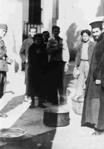 Κατοχή 1944- Φυλακές Αλεξάνδρας. Ο γκεσταπίτης αυστριακός αρχιφύλακας σταματά με νοήματα τη διανομή του συσσιτίου. Δεξιά, ο π. Αλέξανδρος Παπαποστόλου.